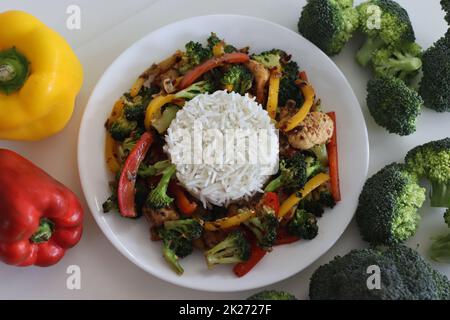 Stir fried vegetables with chicken. Air fried chicken tossed with sauteed bell peppers and broccoli. Served with boiled basmati rice. Shot along with Stock Photo