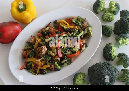 Stir fried vegetables with chicken. Air fried chicken cubes tossed with sauteed bell peppers and broccoli. Shot along with broccoli bunches and bell p Stock Photo