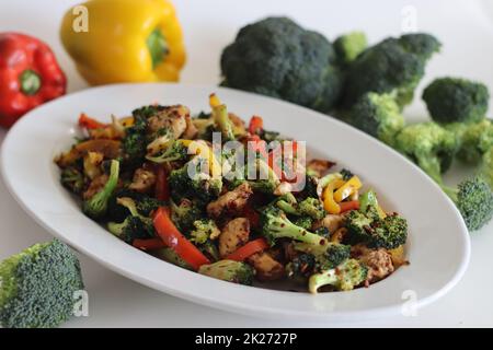 Stir fried vegetables with chicken. Air fried chicken cubes tossed with sauteed bell peppers and broccoli. Shot along with broccoli bunches and bell p Stock Photo