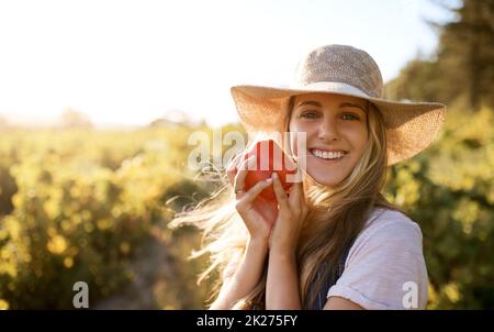 Fresh food is the best food. Shot of a young woman working on a farm. Stock Photo