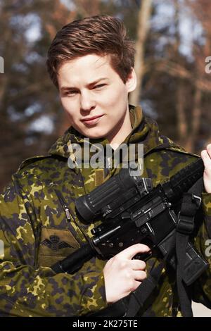Proudly protecting his country. A young soldier standing with a rifle. Stock Photo