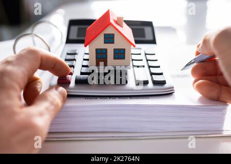Person Hand Calculating A Real Estate Property Stock Photo