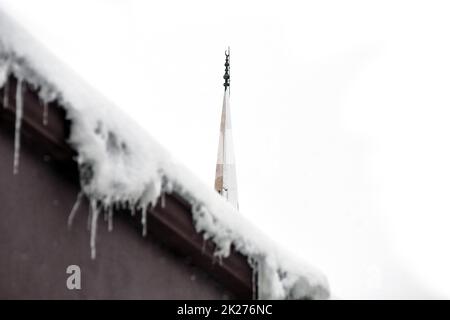 icicles on the roof, it's snowing, it's a hard winter, mosque minaret and it's snowing, hard winter in turkey Stock Photo