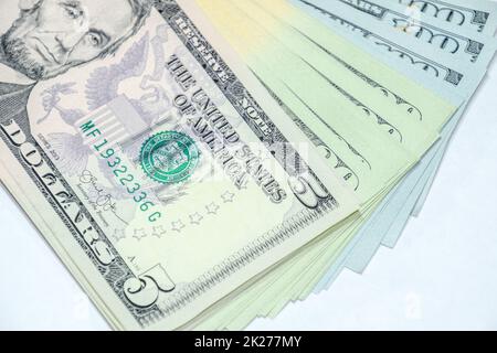cistern of banknotes lies on a white table. Lots of dollars, a wad of dollars. Stock Photo
