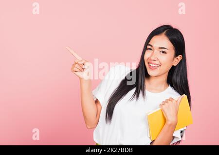 woman confident smiling holding orange book open pointing finger Stock Photo