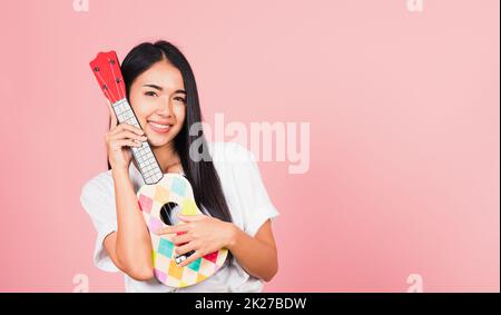 woman teen confident smiling face hold acoustic Ukulele guitar Stock Photo