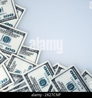 Hundred-dollar bills are scattered in a frame on a white background. Stock Photo