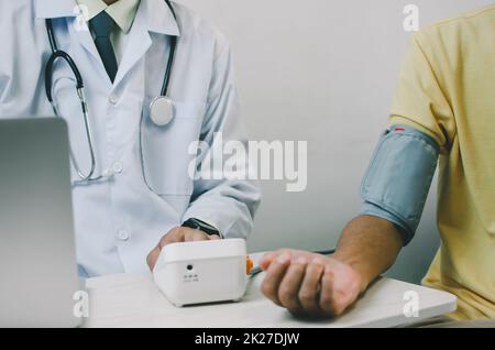 doctor measures the blood pressure of an elderly male patient. Stock Photo