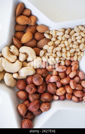 Mixed nuts in a dish in form of stars, close-up Stock Photo
