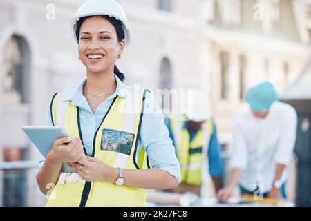Construction, tablet and architecture with a woman builder or architect working on a building site in the city. Engineer, design and technology with a Stock Photo