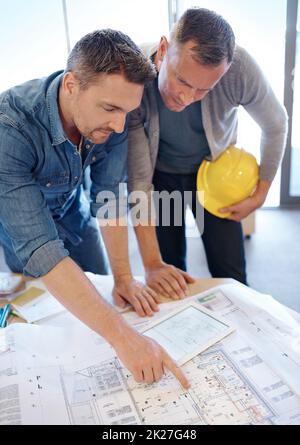 That might work better over there. two architects working together on a blueprint with the help of a digital tablet. Stock Photo