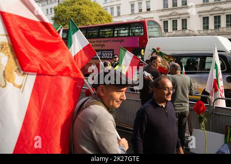 London, UK. 22nd Sep, 2022. Iranians in London protest over Mahsa Amini's death outside the Iranian Embassy, 16 Prince's Gate, London, SW7 1PT. Red roses laid at a commemorative table bearing a photograph of Mahsa Amini, also known as Jina Amini of Kurdish heritage, the young woman who died whilst in the custody of the morality police in Iran over an alleged breach of sumptuary regulations concerning the hijab. Credit: Peter Hogan/Alamy Live News Stock Photo