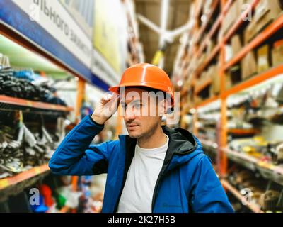 a man measures a helmet in a store Stock Photo