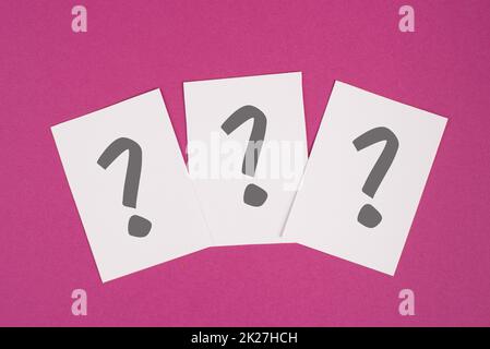Three question marks on paper, colorful background, looking for an answer, searching for knowledge, problem solving concept Stock Photo