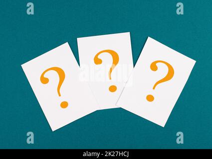 Three question marks on paper, colorful background, looking for an answer, searching for knowledge, problem solving concept Stock Photo