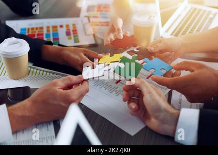 Teamwork of partners connect puzzle pieces as integration and startup Stock Photo