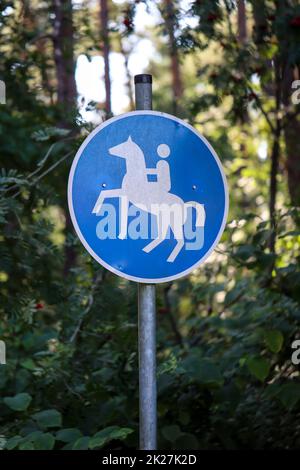 A blue and white sign with a riding horse marks an extra trail. Stock Photo