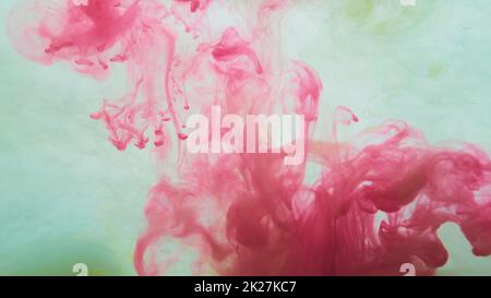 Red paint in the water. abstract background. ink in fluid. colorful splashes in liquid Stock Photo
