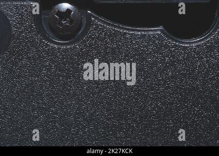 Black plastic surface with screw. detail of plastic cassette Stock Photo