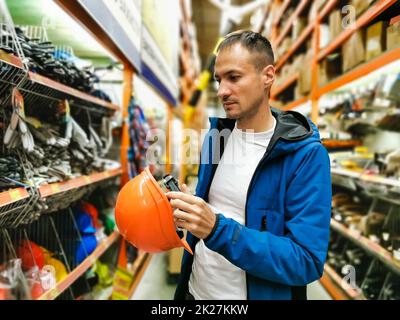 a man measures a helmet in a store Stock Photo