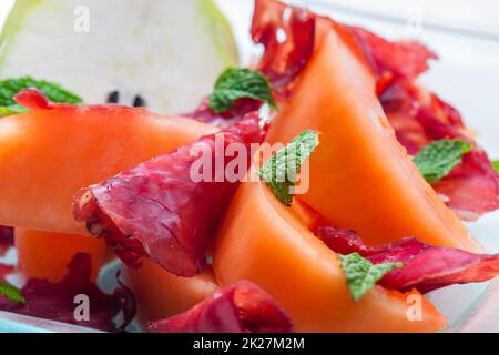 melon cantaloupe and pear with  proscutto and mint leaves Stock Photo