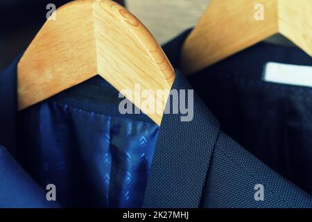 Row of men's suits hanging on rack for sale Stock Photo