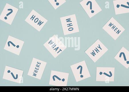 The words who what where how why and when are standing on small pieces of paper, question marks, asking for solution, problem solving Stock Photo
