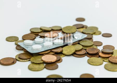 A pile of euro coins and medications pills in the blister pack Stock Photo