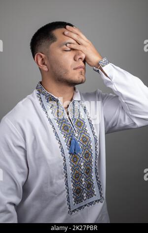 worried with the hand on his face a young latin man with short hair, expression with negative emotions gestures in studio Stock Photo