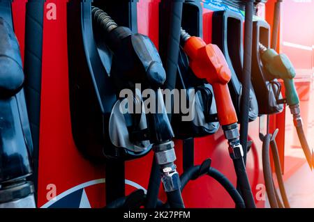 Gas pump nozzle in petrol station. Fuel nozzle in oil dispenser. Fuel dispenser machine. Refueling fill up with petrol gasoline and diesel. Petrol industry and service. Petroleum oil consumption. Stock Photo