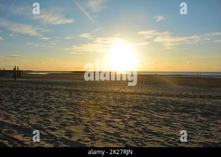 Sunset at low tide over the sand beach Stock Photo
