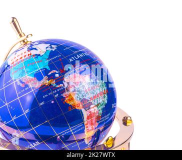 blue glass globe on the yellow shiny metal stand isolated on white background Stock Photo