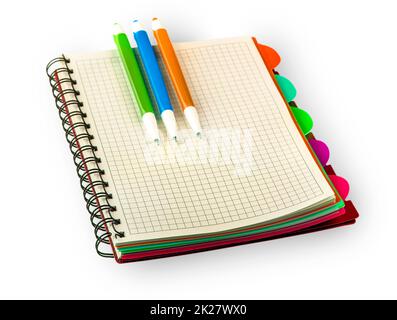 red Diary notebook and colored pens isolated on white background. Stock Photo