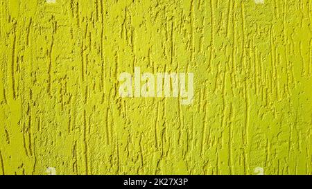 Old gold plaster wall texture yellow background. Textured textured wall plaster. Embossed wall decoration. Stucco walls. Embossed wall decoration. Decorative plaster is painted yellow. Stock Photo