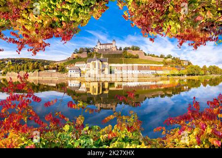 Wurzburg. Main river waterfront and scenic Wurzburg castle and vineyards reflection view through autumn leaves Stock Photo