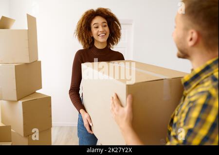 Happy multiethnic couple carrying cardboard box together Stock Photo