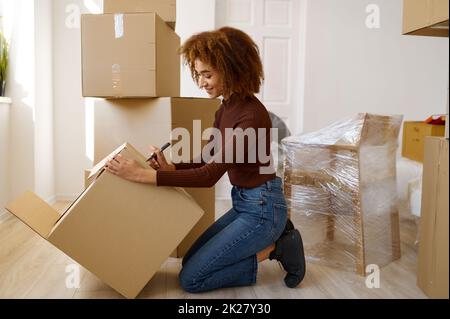 Side view portrait woman signing cardboard box Stock Photo