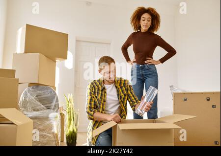 Couple packing stuff among plenty of boxes Stock Photo - Alamy