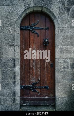 Vintage, old wooden door in Gothic style with iron hinge and frame in Glasnevin Cemetery, Ireland Stock Photo