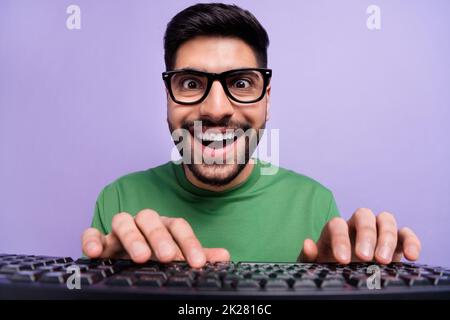 Photo of handsome geek nerd coder in spectacles green pullover writing code making new application isolated on purple color background Stock Photo