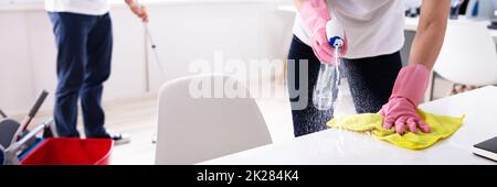 Two Young Janitor Cleaning The Office Stock Photo