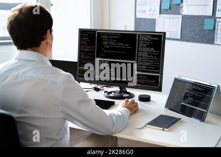 Computer Programmer Writing Program Code On Computer Stock Photo