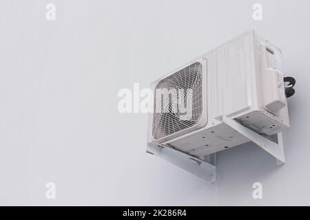 Outdoor air conditioner split system unit on white wall with copy space Stock Photo