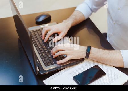 hand man work using laptop with papers, smartphone and mouse on work table Stock Photo