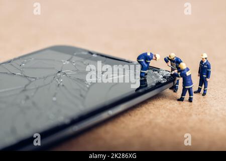 Team of specialists repairing broken phone. Technology concept Stock Photo