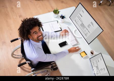 African Accountant With Disability Working On Computer Stock Photo