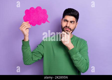 Photo portrait of young hispanic man hold pink cloud not believe suspect dressed stylish green outfit isolated on violet color background Stock Photo