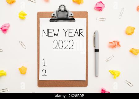 Hand writing sign New Year 2022. Business approach Greeting Celebrating Holiday Fresh Start Best wishes Multiple Assorted Collection Office Stationery Photo Placed Over Table Stock Photo