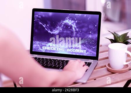 Writing displaying text Checking Account. Business overview transactional bank charge used to debit all the expenses Hand Typing On Laptop Beside Coffe Mug And Plant Working From Home. Stock Photo