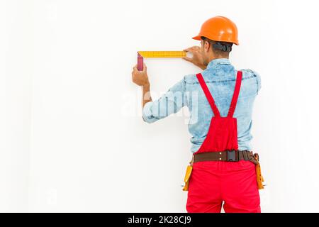 Construction worker pulling a rope. Full length studio shot isolated on white. Stock Photo